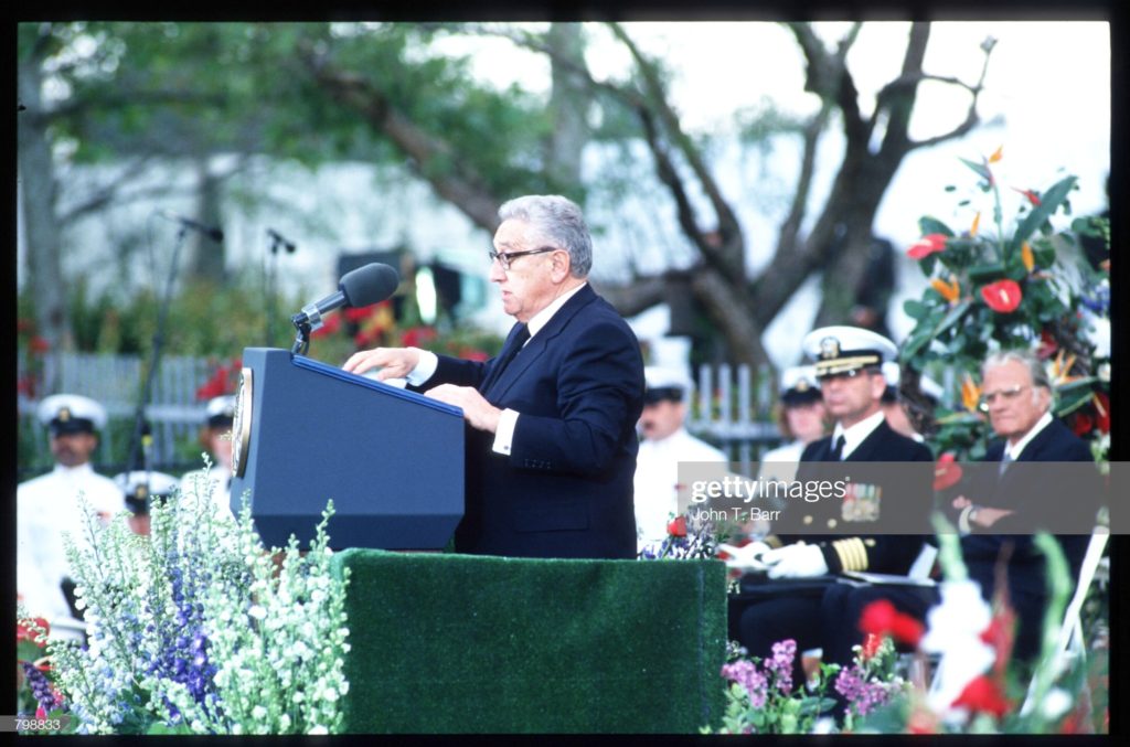 Henry Alfred Kissinger speaking at podium, Richard Milhous Nixon memorial service, the Reverend Billy Graham at the far right of photograph, Yorba LInda, California, Wednesday, 27 April 1994. (Photographer John T. Barr / Hulton Archive via Getty Images.)